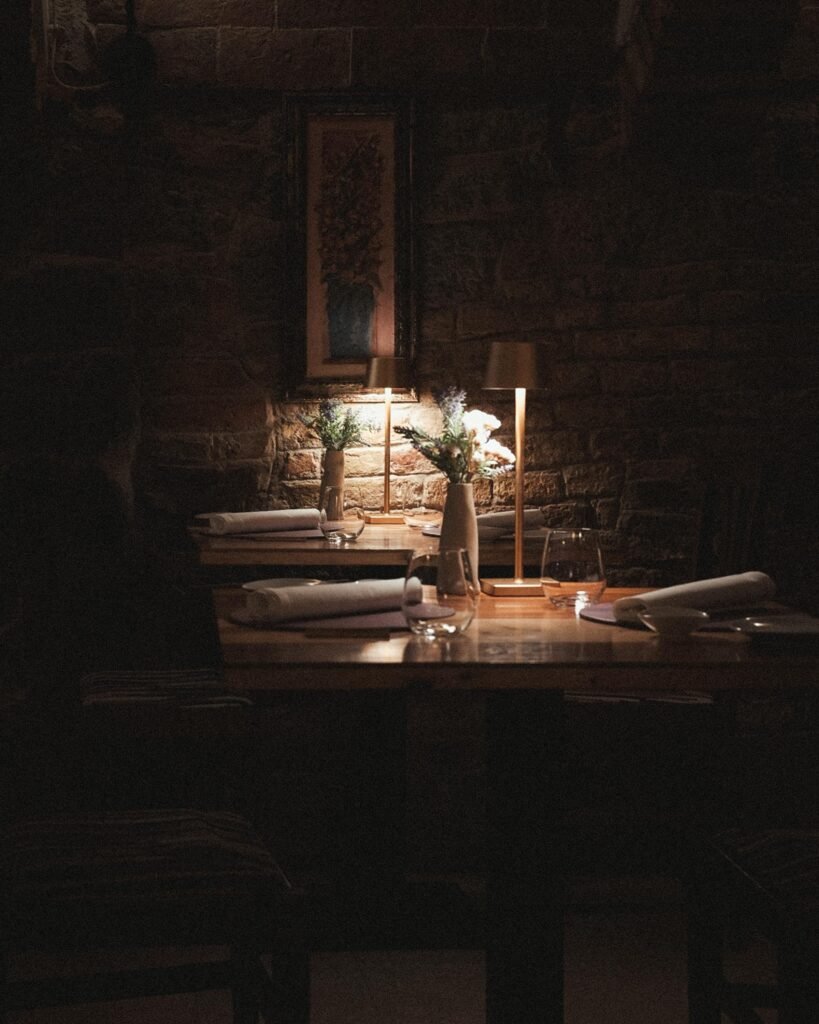 Styled shot — Dukinpam 11-Light Sputnik installed above a moody, candlelit table with warm brass accents